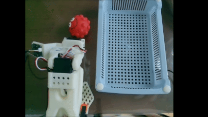 Early pick-and-place attempt using a red squishy ball and a random basket